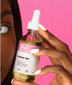 Her Fantasy Box Renew Her facial serum held by a woman with white manicured nails against a pink background.